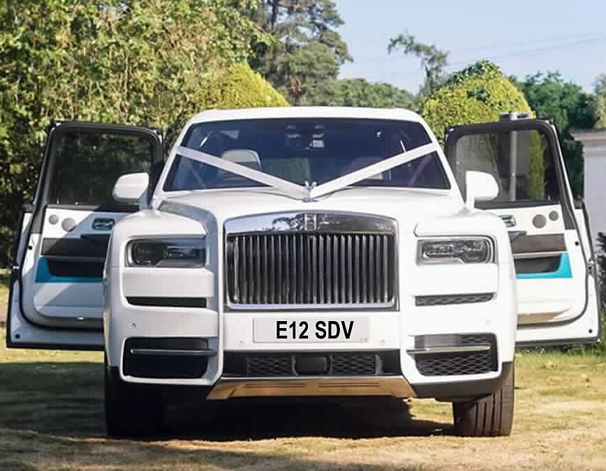 White Rolls-Royce Cullinan wedding car with ribbons