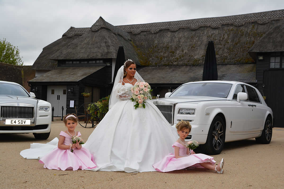 Bride + bridesmaids and two Rolls Royce wedding cars at the wedding venue